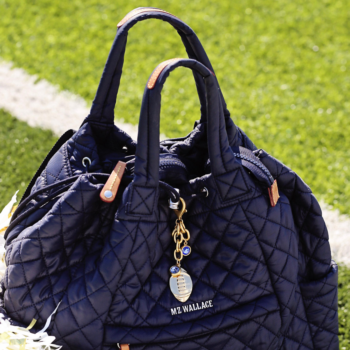 Quilted navy handbag with 'Me Wallace' tag on grass