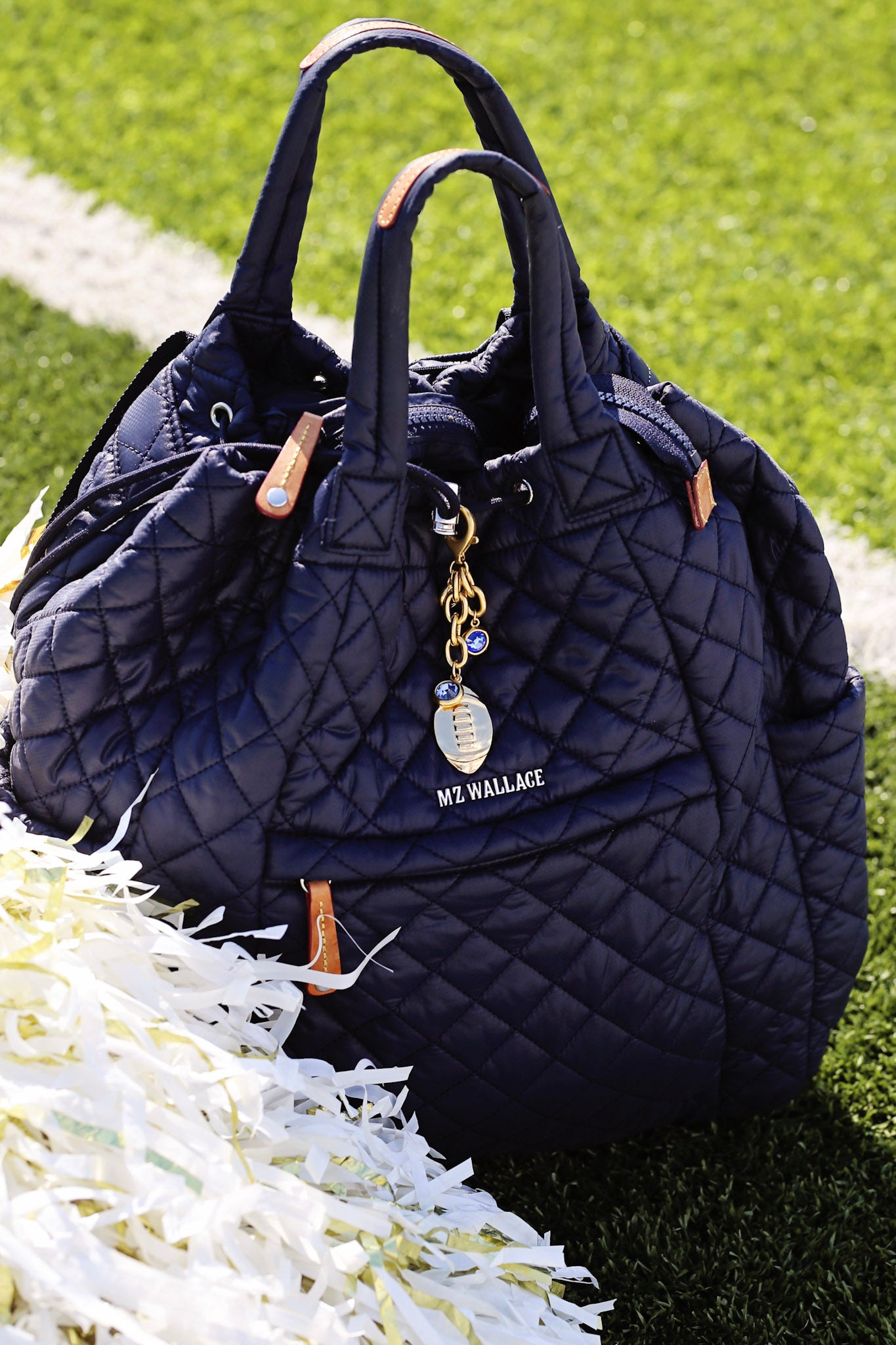 Quilted navy handbag with 'Me Wallace' tag on grass