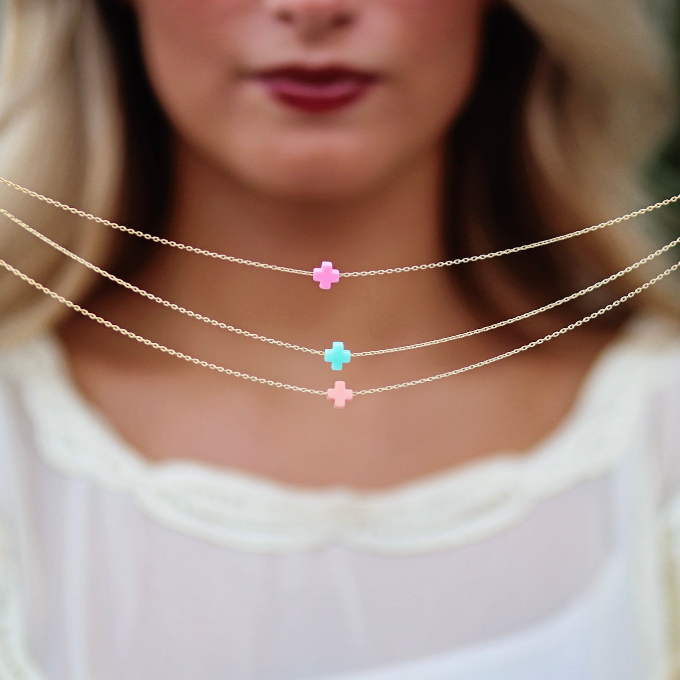 gold necklace with colorful cross