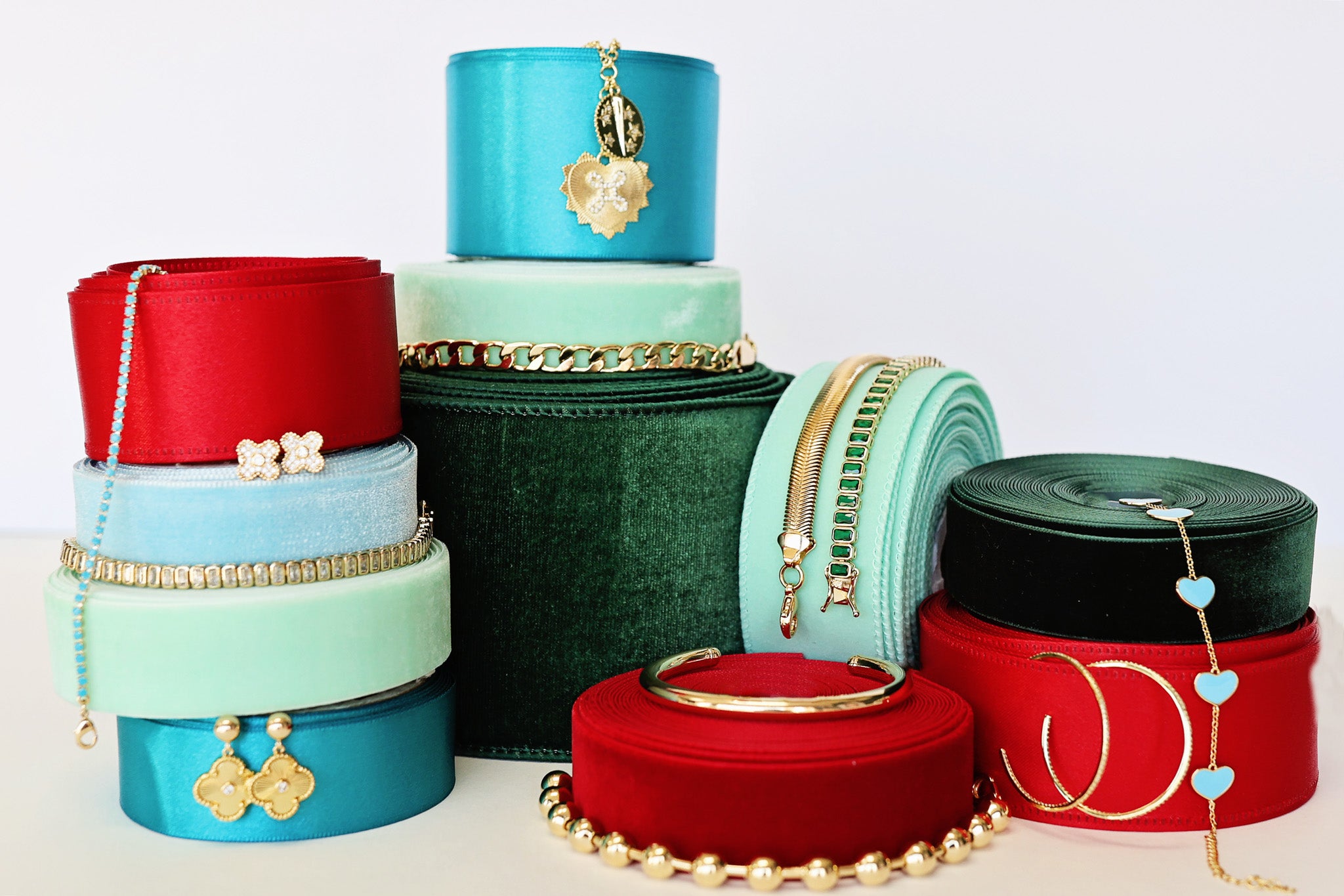 Stack of colorful jewelry boxes with jewelry on a white background