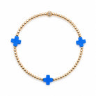 Bracelet with blue cross charms and gold beads on a white background